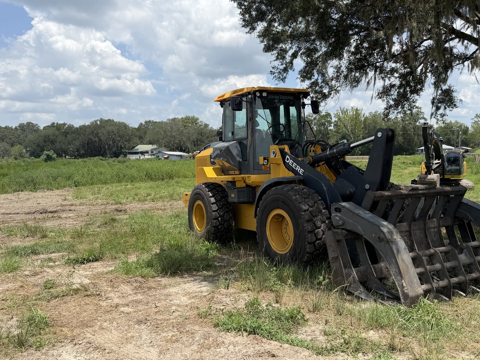 The John Deere 544 wheel loader and 210 excavator together on a cleared work site